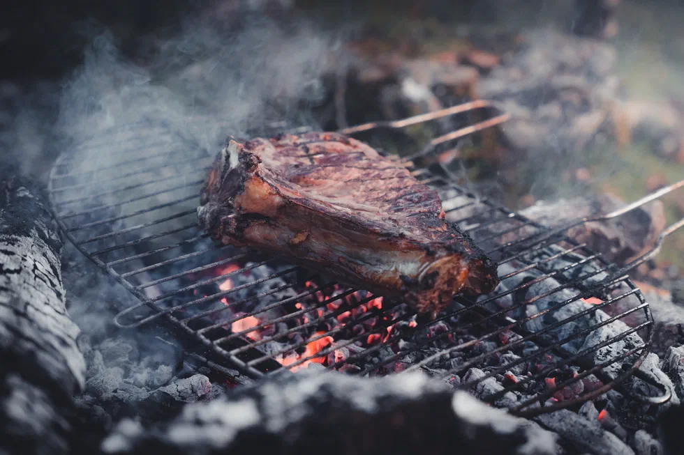 Pièce de viande cuite au feu de bois pendant le bivouac