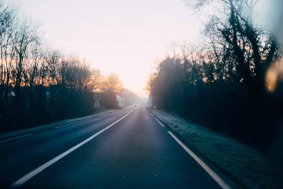 Route au petit matin avec lueurs de lever de soleil