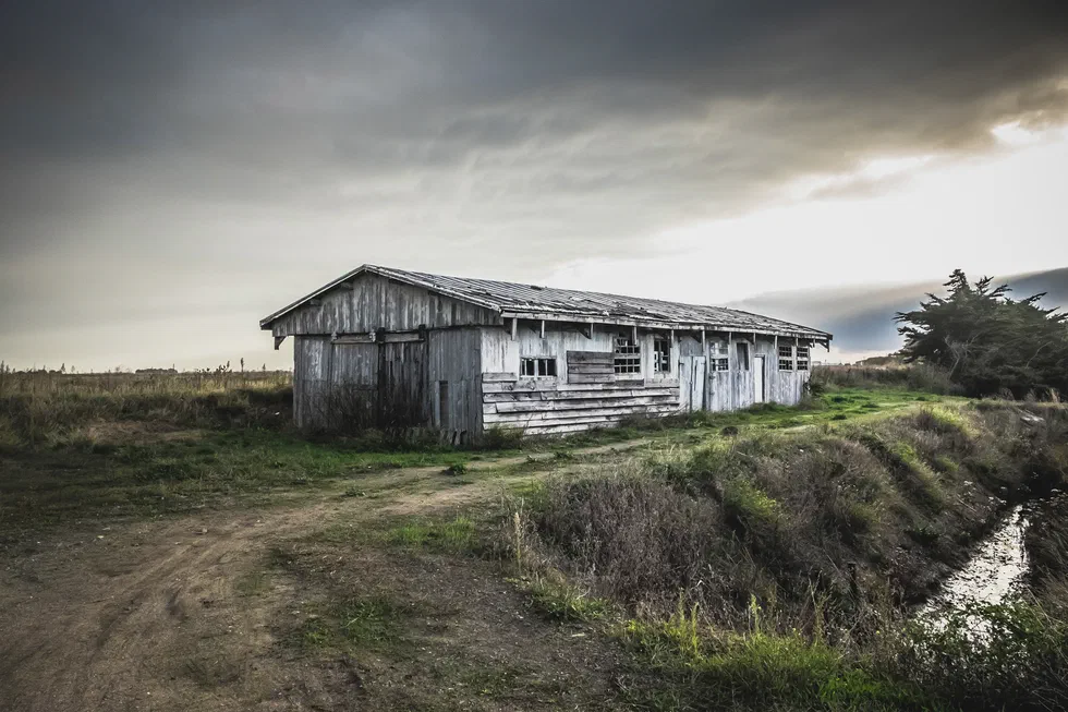 Ancien cabanon en bois sous un ciel orageux