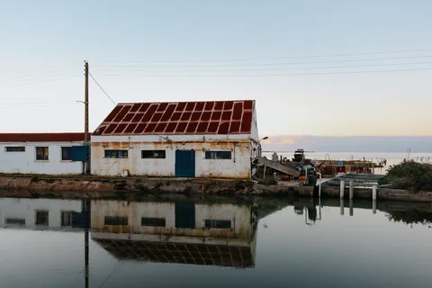 Bâtiment de pêche sur canal au lever du jour avec reflet