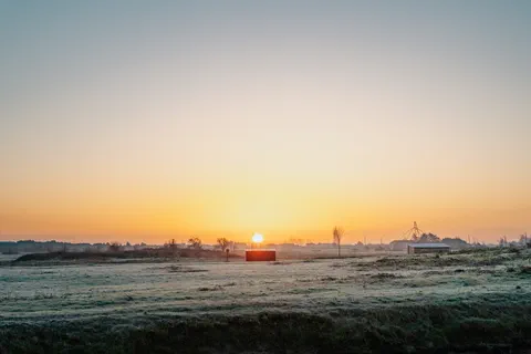 Lever de soleil sur une prairie gelée