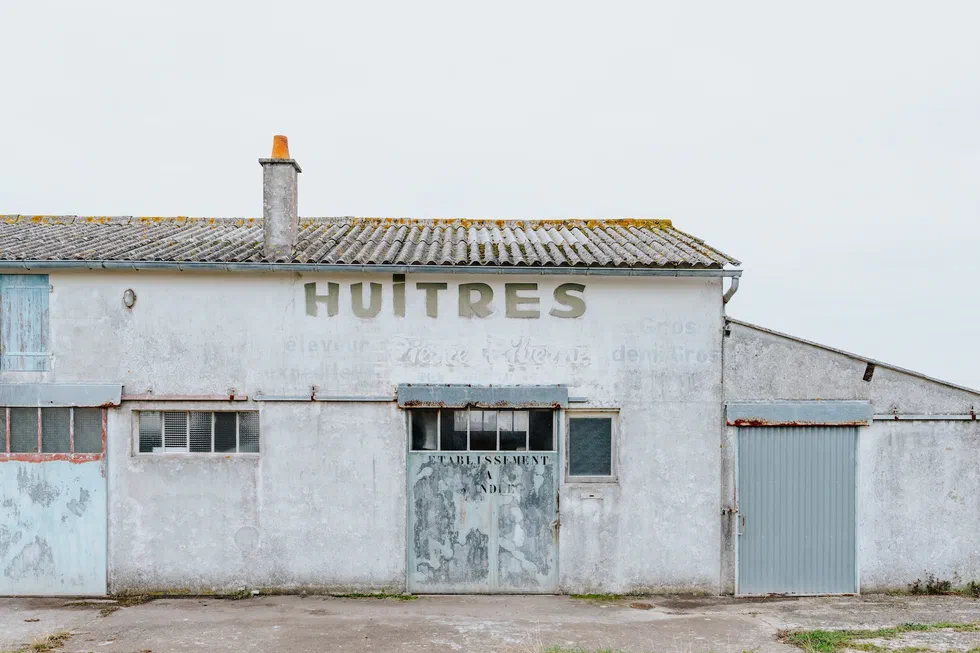 Façade d’un ancien bâtiment ostréicole avec l’enseigne Huitres