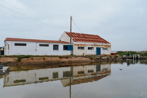 Ancienne cabane blanche au bord de l&rsquo;eau avec son reflet