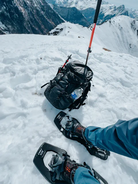 Gros plan sur les raquettes TSL 2.28 HIKE utilisées lors de la randonnée, posées dans la neige fraîche, avec les chaussures SH500 Mountain MID visibles.