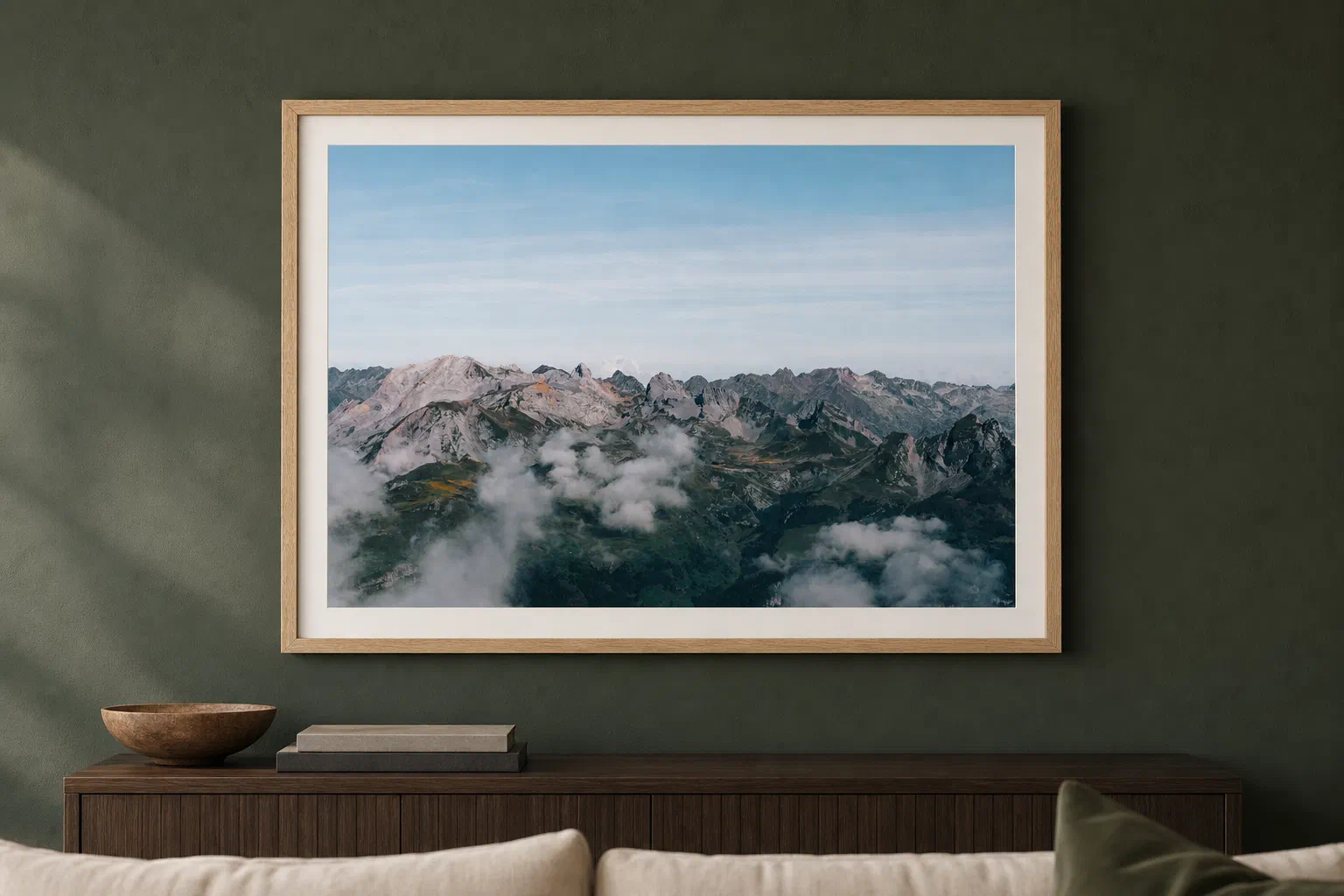 Chaîne pyrénéenne au-dessus des nuages présenté dans un cadre en chêne sur un mur vert sombre