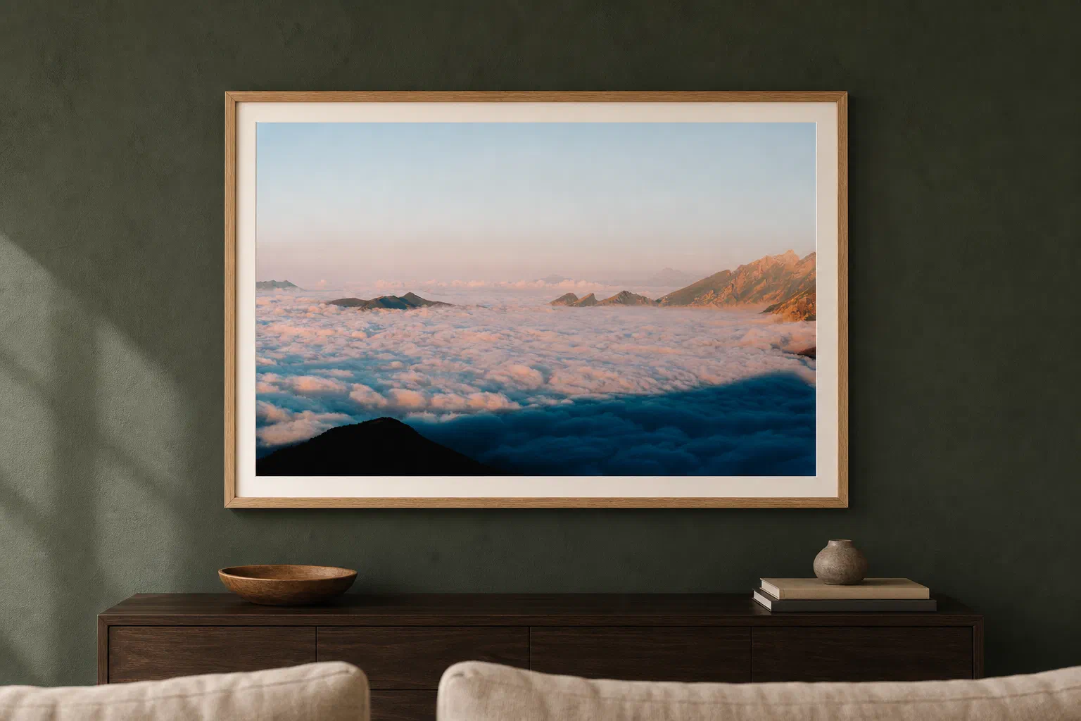 Océan de nuages pastel présenté dans un cadre en chêne sur un mur vert sombre